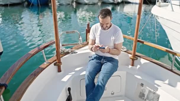 Hombre Mediana Edad Con Teléfono Inteligente Sentado Barco Puerto — Vídeos de Stock