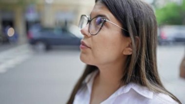 Genç ve güzel İspanyol kadın, gülümseyen gözlüklü, mutlu Madrid sokaklarına bakıyor.