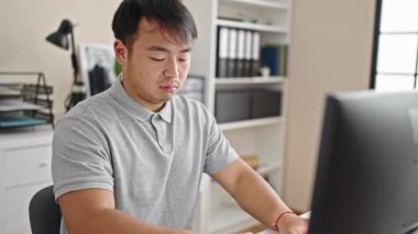 Ofiste çalışan bilgisayar ve akıllı telefon kullanan bir iş adamı.