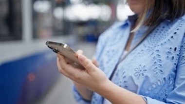 Genç ve güzel İspanyol kadın Viyana sokaklarında akıllı telefon kullanıyor.