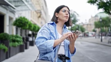 Genç ve güzel İspanyol bir kadın Viyana sokaklarında akıllı telefon kullanan bir arkadaşıyla buluşuyor.
