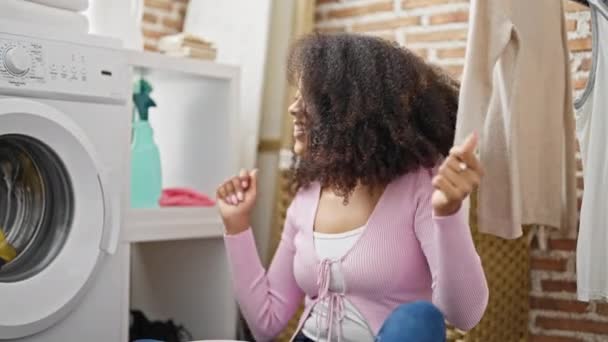 洗濯機が洗濯室で踊るのを待っているアフリカ系アメリカ人女性 — ストック動画