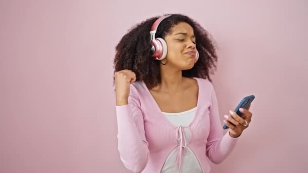 Mujer Afroamericana Escuchando Música Bailando Sobre Fondo Rosa Aislado — Vídeos de Stock