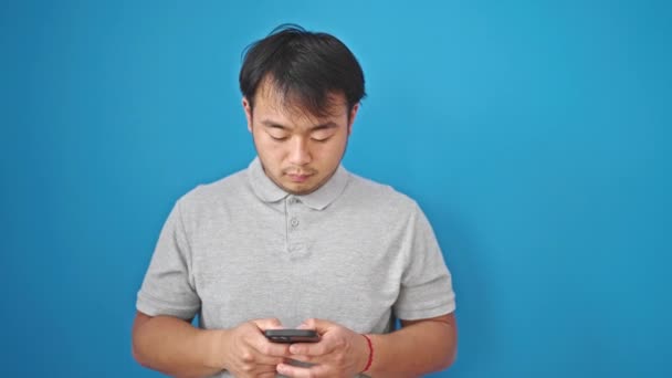 用智能手机笑对孤立的蓝色背景 — 图库视频影像