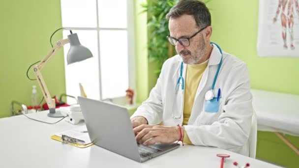Middle Age Man Doctor Using Laptop Working Clinic — Video