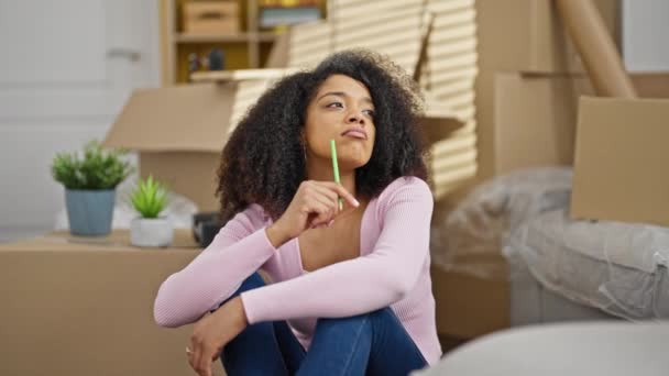 アフリカ系アメリカ人の女性が新しい家で考えて床に座って — ストック動画