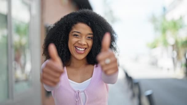 Mujer Afroamericana Sonriendo Confiado Haciendo Signo Con Pulgares Arriba Calle — Vídeos de Stock