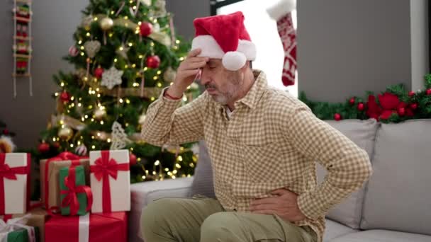 Hombre Mediana Edad Sentado Sofá Por Árbol Navidad Que Sufre — Vídeo de stock