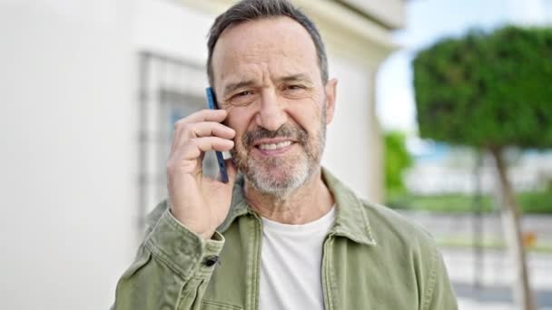 Homem Meia Idade Sorrindo Confiante Falando Smartphone Rua — Vídeo de Stock