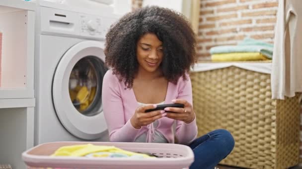 洗濯室で洗濯機を待っているアフリカ系アメリカ人の女性 — ストック動画