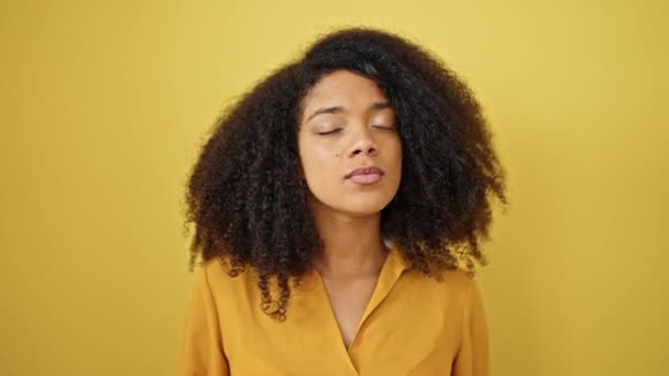 Mujer Afroamericana Pie Con Expresión Seria Sobre Fondo Amarillo Aislado — Vídeos de Stock