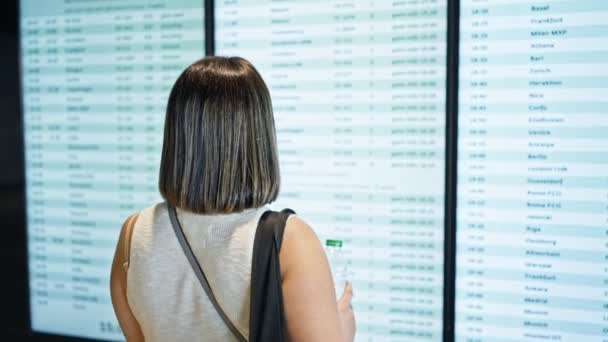 Young Beautiful Hispanic Woman Looking Flight Destination Display Airport — Stock Video