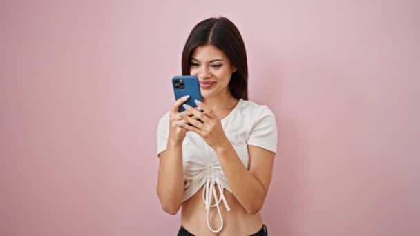 Jovem Mulher Caucasiana Usando Smartphone Sorrindo Sobre Fundo Rosa Isolado — Vídeo de Stock