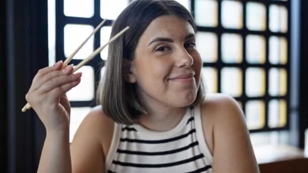 Joven Hermosa Mujer Hispana Sonriendo Sentada Mesa Sosteniendo Palillos Restaurante — Vídeos de Stock