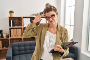 Muayenehanede çalışan genç bir kadın kendini vuruyor ve öldürüyor. Silah gibi el ve parmakları işaret ediyor. İntihar jesti.. 