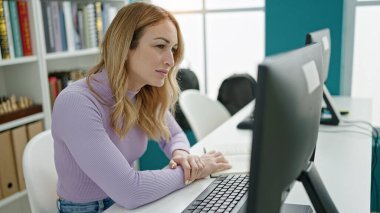 Kütüphane üniversitesinde bilgisayar kullanan güzel İspanyol bir kız öğrenci.