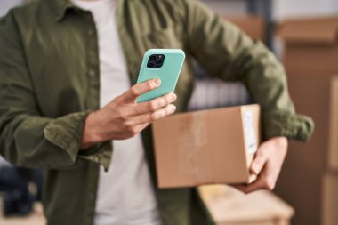 Kafkasyalı genç bir iş adamı ofiste akıllı telefon paketi kullanıyor.