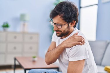 Evdeki kanepede oturan İspanyol bir adam sırt ağrısı çekiyor.