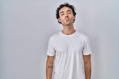 İspanyol bir adam, izole edilmiş arka planda durup kameraya bakarak canlı yayında güzel ve seksi bir öpücük yolluyor. aşk ifadesi. 