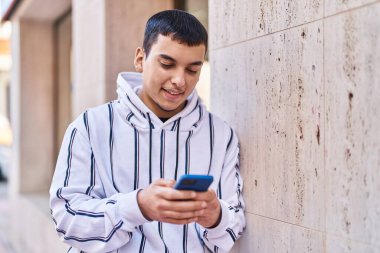 Sokakta akıllı telefon kullanan kendine güvenen genç adam.