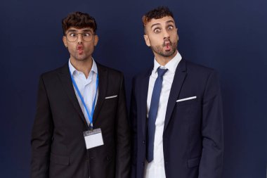 İki İspanyol iş adamı iş kıyafetleri giyip dudaklarıyla balık suratı yapıyorlar, çılgınca ve komik bir jest. Komik ifade. 