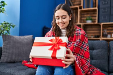 Young hispanic woman opening gift box smiling with a happy and cool smile on face. showing teeth. 