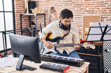 Genç İspanyol müzisyen müzik stüdyosunda elektro gitar çalıyor.