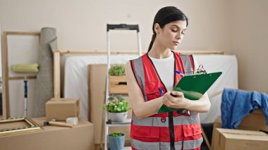 Genç, güzel İspanyol kadın müteahhit yeni evindeki panoya yazı yazıyor.