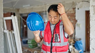  İnşaat alanında kendine güveni olan, saçlarını tarayan inşaatçı.