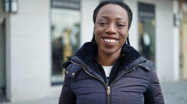 Sokakta kendine güvenen Afrikalı Amerikalı kadın gülümsüyor