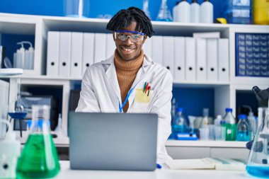 Laboratuvarda dizüstü bilgisayar kullanan Afrikalı Amerikalı bilim adamı.