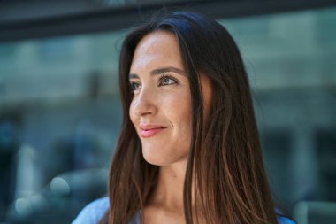 Young beautiful hispanic woman smiling confident looking to the side at street