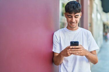 Sokakta akıllı telefon kullanan, kendine güvenen genç bir İspanyol.