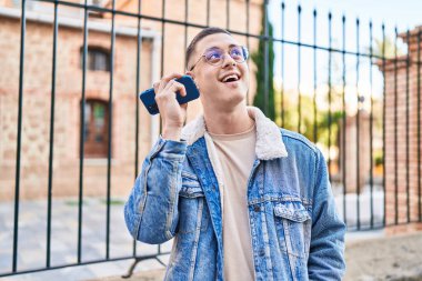 Genç İspanyol adam gülümsüyor. Caddedeki akıllı telefondan kendine güvenen bir sesli mesaj dinliyor.