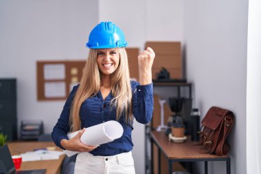 Mimar şapkası takan genç bir kadın öfkeyle bağırıyor, öfkeyle bağırıyor ve el kaldırıyor. 