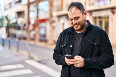 Sokakta akıllı telefon kullanan, kendine güvenen genç bir İspanyol.