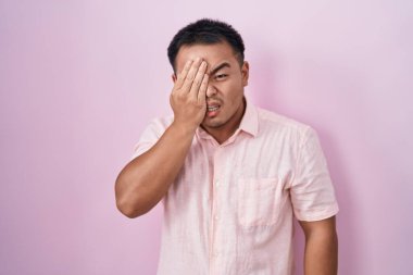 Pembe arka planda duran Çinli genç adam... yarım yüz, göz ve ağız kaplamasından yorgun düşüyor. Yüzüm acıyor.. 