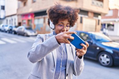 African american woman executive playing video game at street