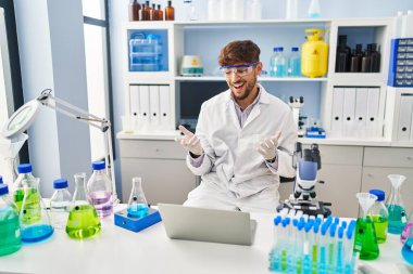 Young arab man scientist having video call working at laboratory
