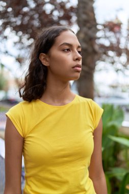 Young african american woman looking to the side with serious expression at park