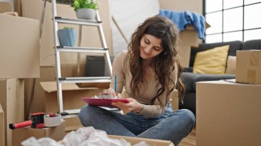 Genç, güzel, İspanyol bir kadın. Yeni evimizde yerde oturuyor.