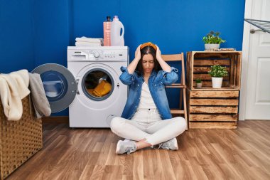 İspanyol kadın çamaşırlarını yıkıyor baş ağrısı ve stresten acı çekiyor çünkü acı ve migren. Eller başının üstünde.. 