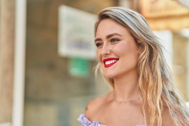 Young beautiful hispanic woman smiling confident looking to the side at street