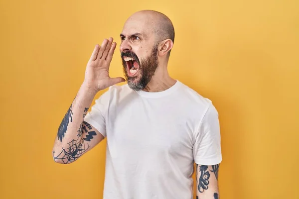 Mladý Hispánec Tetováním Stojící Nad Žlutým Pozadím Křičící Křičící Stranu — Stock fotografie