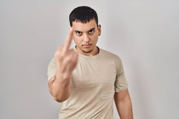 Young arab man wearing casual t shirt showing middle finger, impolite and rude fuck off expression 