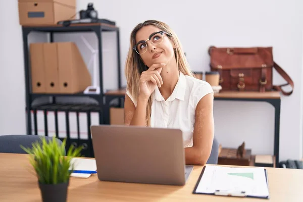Young Blonde Woman Working Office Wearing Glasses Serious Face Thinking —  Fotos de Stock