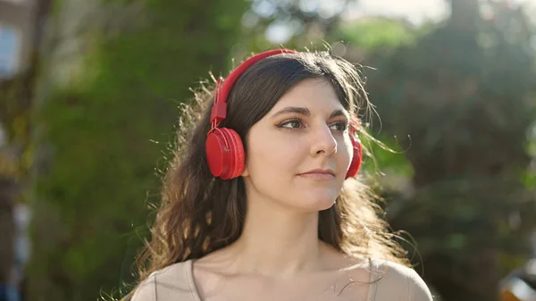 Young Beautiful Hispanic Woman Listening Music Serious Expression Park — Zdjęcie stockowe