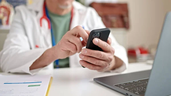 Średni Wiek Siwe Mężczyzna Lekarz Pomocą Smartfona Laptopa Pracy Klinice — Zdjęcie stockowe