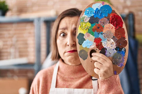 Middle Age Hispanic Woman Holding Painter Palette Close Face Skeptic — Stock Photo, Image