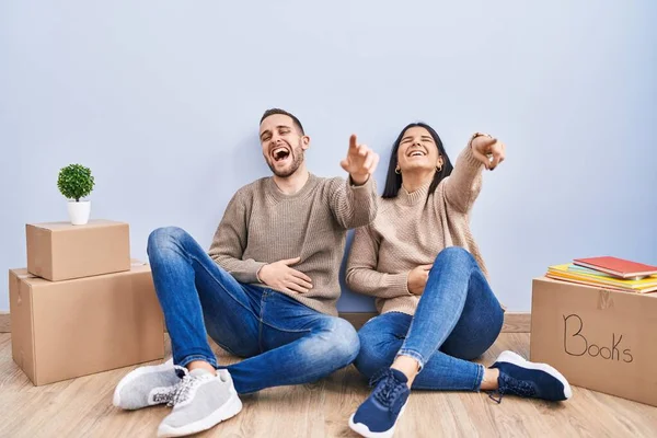 Young Couple Moving New Home Laughing You Pointing Finger Camera — Stock Photo, Image